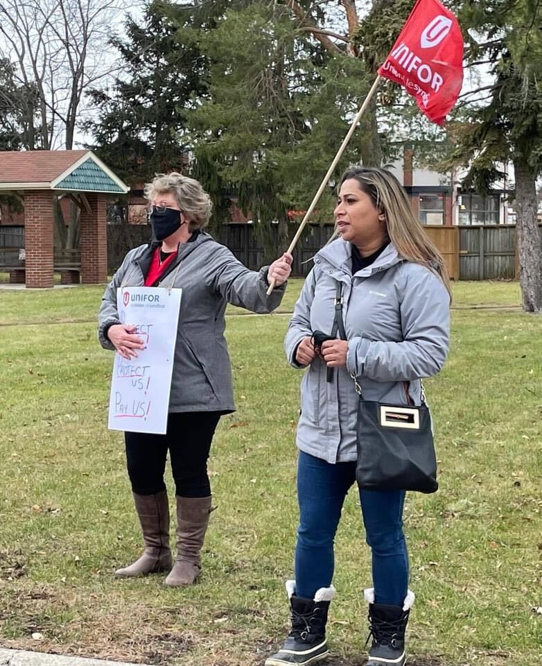 Naureen Rizvi Stans with a member holding a picket sign and Unifor flag