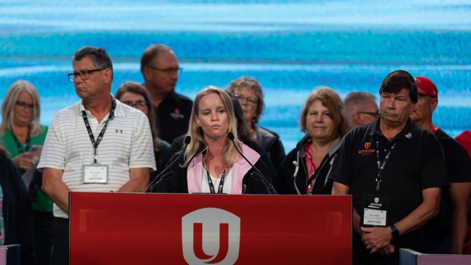 A group of people at a red Unifor podium.